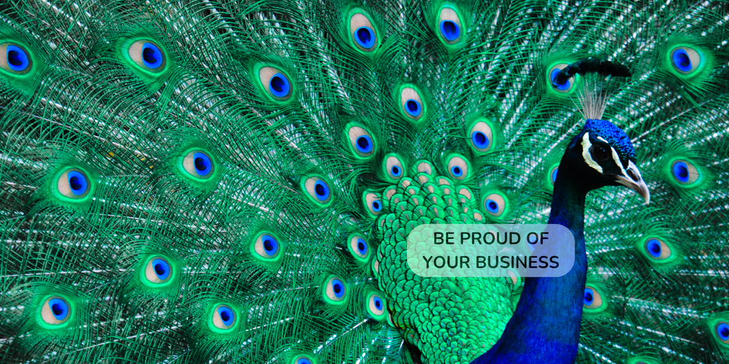 Peacock with its feathers spread wide, displaying vibrant green and blue colors with a text overlay. - Be Proud of Your Business